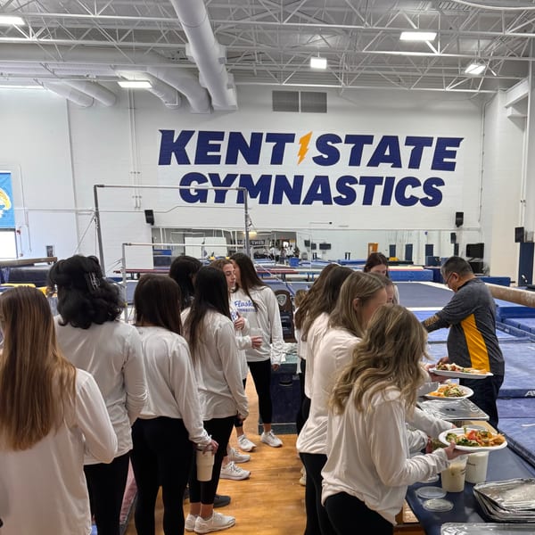 Gymnasts in white shirts and black leggings line up for Mexican food from Casa Nueva.