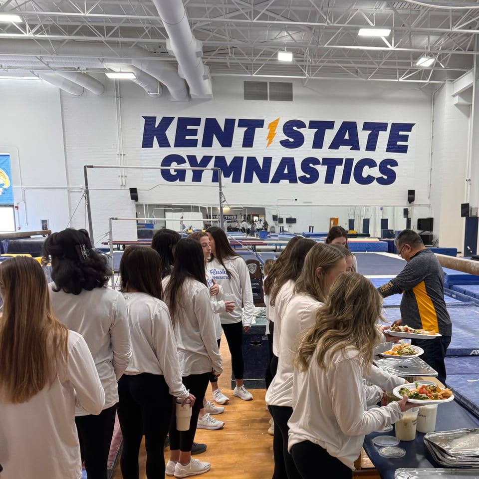 Gymnasts in white shirts and black leggings line up for Mexican food from Casa Nueva.